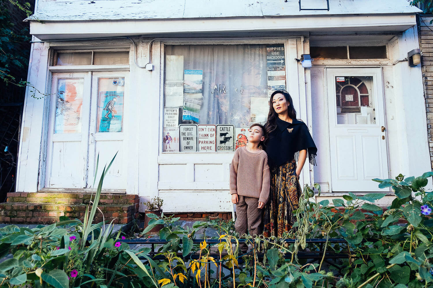 family portrait of mom and son posing in front of a vintage looking white building in Brooklyn