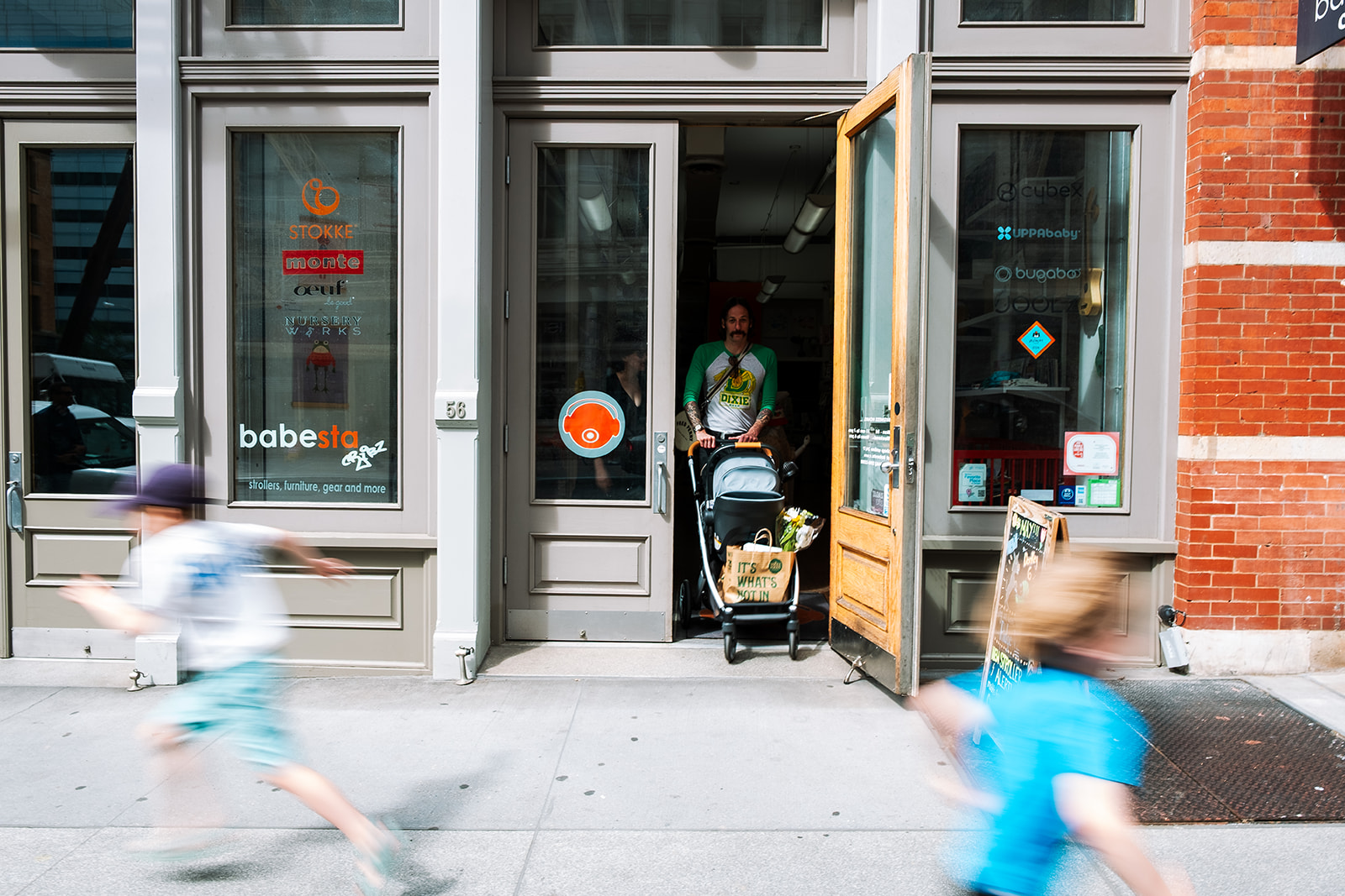 Babesta kids store exterior in TriBeCa New York City with children running past on the sidewalk