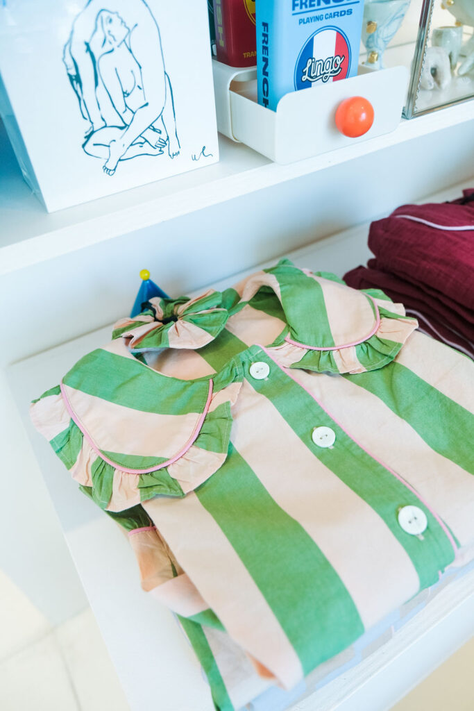 Green and pink striped ruffle collar womens pajamas folded on shelf at Take Me With You boutique Ace Hotel Brooklyn New York City