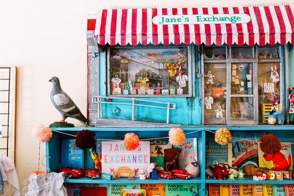 Handmade miniature diorama of Janes Exchange storefront with books toys and a pigeon inside the East Village New York City shop