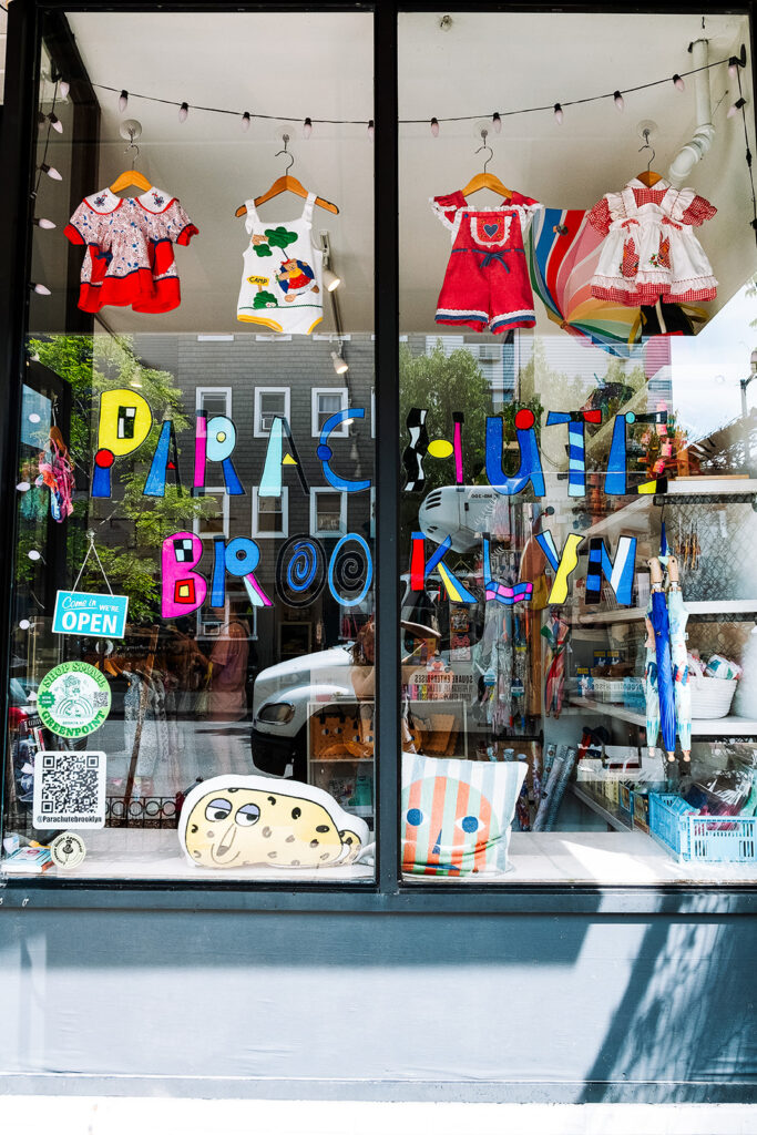 Brooklyn kids store exterior with colorful hand painted lettering vintage kids clothing and cushions in window Greenpoint Brooklyn New York