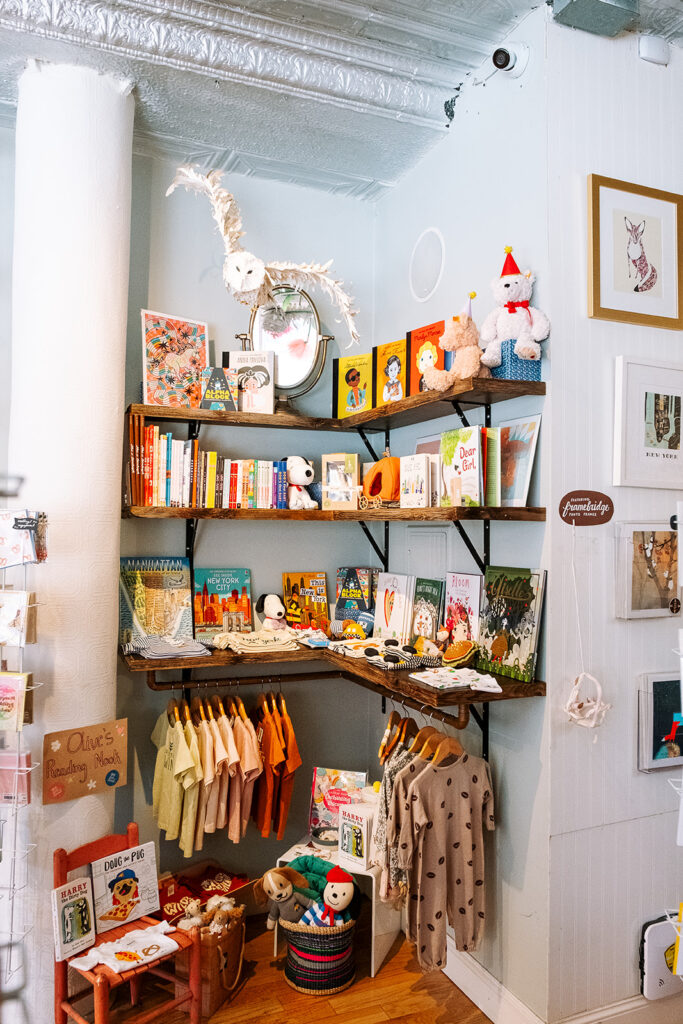 Interior shelves with childrens books toys and clothing at Pink Olive gift boutique West Village New York City